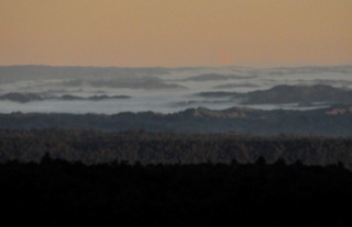 In the distance, viewing from Chateau Tongariro in the evening, mountaintops protruding above a layer of clouds